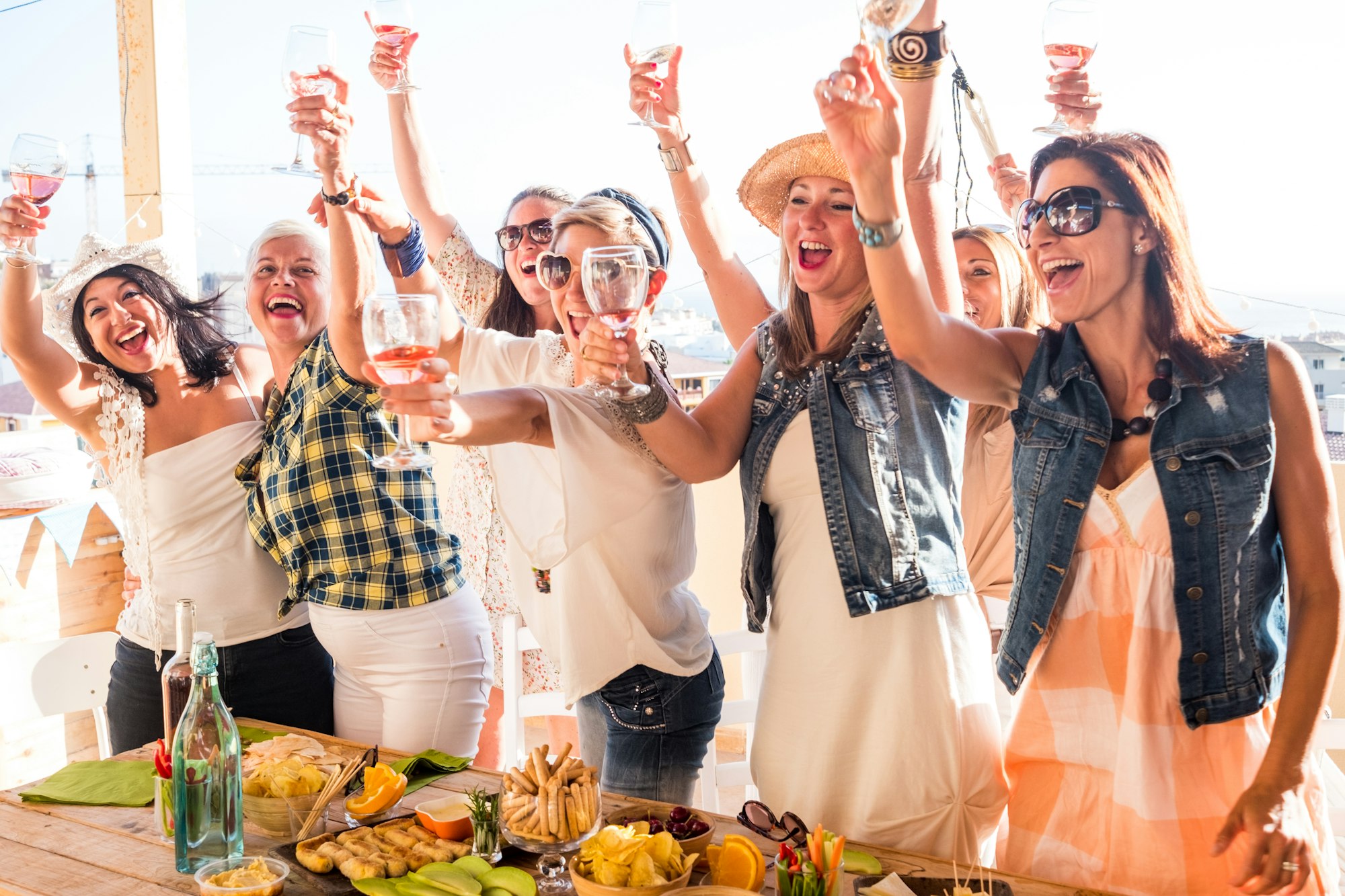 Group of happy beautiful women celebrating the party toasting with some wine glass